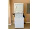 Picture shows a modern, efficient, stacked washer and dryer laundry setup against tan colored walls at 8412 Grove Blvd, Punta Gorda, FL 33982
