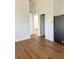 Open living space with wood-look flooring includes a refrigerator, doorway, and overhead lighting at 8412 Grove Blvd, Punta Gorda, FL 33982