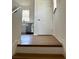 View from a staircase landing towards a kitchen featuring hardwood floors and stainless steel appliances at 8412 Grove Blvd, Punta Gorda, FL 33982