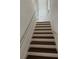 Staircase with dark wood treads and white risers, featuring a metal handrail at 8412 Grove Blvd, Punta Gorda, FL 33982