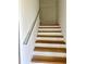 Staircase featuring wooden steps, white risers, a metal handrail and bright lighting at 8412 Grove Blvd, Punta Gorda, FL 33982