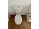 Top-down view of a white toilet and wood-look flooring in the renovated bathroom at 8412 Grove Blvd, Punta Gorda, FL 33982