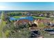Aerial view featuring condos, golf course and mature trees at 8422 Wethersfield Run # 103, Lakewood Ranch, FL 34202