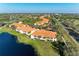 Wide aerial view of the property with its red tile roofs and proximity to lakes, roads, and lush greenery at 8422 Wethersfield Run # 103, Lakewood Ranch, FL 34202