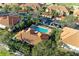 Aerial view of a community pool and several residences with red tile roofs and mature landscaping at 8422 Wethersfield Run # 103, Lakewood Ranch, FL 34202