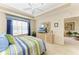 Relaxing bedroom with a tray ceiling, ceiling fan, and serene decor at 8422 Wethersfield Run # 103, Lakewood Ranch, FL 34202
