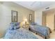 Charming guest bedroom with matching twin beds and decorative mirrors at 8422 Wethersfield Run # 103, Lakewood Ranch, FL 34202