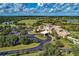 Stunning aerial view of the grand clubhouse, golf course, and lush landscaping under a beautiful sky at 8422 Wethersfield Run # 103, Lakewood Ranch, FL 34202