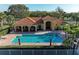 Community pool features a covered seating area, lounge chairs, and lush landscaping at 8422 Wethersfield Run # 103, Lakewood Ranch, FL 34202