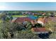 Elegant condo building featuring a terracotta roof with scenic views overlooking a lush golf course and serene lake at 8422 Wethersfield Run # 103, Lakewood Ranch, FL 34202