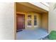 Cozy front porch featuring a stylish door, textured walls, and elegant sidelight windows at 8422 Wethersfield Run # 103, Lakewood Ranch, FL 34202