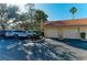 Attached garage with two parking spaces and a red tile roof, surrounded by lush greenery at 8422 Wethersfield Run # 103, Lakewood Ranch, FL 34202