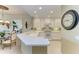 Bright kitchen with white cabinetry, tile backsplash, and a breakfast bar open to the dining area at 8422 Wethersfield Run # 103, Lakewood Ranch, FL 34202
