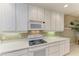 This bright kitchen showcases white appliances, a tile backsplash, and pristine countertops at 8422 Wethersfield Run # 103, Lakewood Ranch, FL 34202