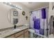 Stylish bathroom featuring granite counters, oval mirror, and shower-tub combo at 8926 Manor Loop # 201, Lakewood Ranch, FL 34202