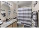 Bright bathroom featuring granite counters, oval mirror, and shower-tub combo at 8926 Manor Loop # 201, Lakewood Ranch, FL 34202