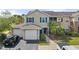Charming townhome with a two-car garage, complemented by a well-maintained lawn and colorful blue door and window trim at 8926 Manor Loop # 201, Lakewood Ranch, FL 34202