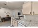 Bright kitchen with granite countertops, stainless steel sink, and open view of the dining and living area at 8926 Manor Loop # 201, Lakewood Ranch, FL 34202