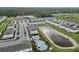 An aerial view of a community with modern townhomes, a pool, and a pond at 9064 Driven Snow St, Sarasota, FL 34241