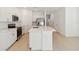 Modern kitchen with stainless steel appliances, spacious island, and white cabinetry with easy access to stairs at 9064 Driven Snow St, Sarasota, FL 34241
