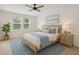 Cozy bedroom featuring a ceiling fan, a bed with blue accents, and natural light from two windows at 9064 Driven Snow St, Sarasota, FL 34241