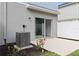 Concrete patio with sliding glass door, small garden, and air conditioner unit at 9064 Driven Snow St, Sarasota, FL 34241