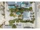 Overhead shot of a property featuring a pool, lush palms, and a rooftop terrace with outdoor seating at 104 Magnolia Ave, Anna Maria, FL 34216