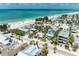 Stunning aerial view showcasing a vibrant coastal community next to a beautiful sandy beach at 104 Magnolia Ave, Anna Maria, FL 34216