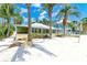 Charming yellow cottage with tropical landscaping near the beach and beautiful blue skies at 104 Magnolia Ave, Anna Maria, FL 34216