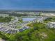 A picturesque aerial view of a well-planned community with a central lake and lush landscaping at 10962 High Noon Trl, Parrish, FL 34219