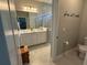 Well-lit bathroom with double vanity, a large mirror, and a glass-enclosed shower with tiled walls at 10962 High Noon Trl, Parrish, FL 34219