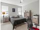 Bright bedroom with neutral tones, a comfortable bed, side tables, and a dresser with modern accents at 10962 High Noon Trl, Parrish, FL 34219