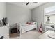 Clean bedroom with neutral tones, a simple bed, guitar, and a window for natural light at 10962 High Noon Trl, Parrish, FL 34219