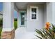 Inviting entrance features a teal door, decorative brickwork, and colorful garden accents at 10962 High Noon Trl, Parrish, FL 34219