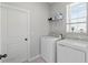Functional laundry room equipped with a modern washer, dryer, shelving and a window at 10962 High Noon Trl, Parrish, FL 34219