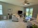 Cozy living room featuring neutral tones, comfortable seating, and a sliding door to the outside at 10962 High Noon Trl, Parrish, FL 34219