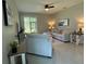 Cozy living room with a comfortable sofa, armchair, ceiling fan, and sliding glass doors to the patio at 10962 High Noon Trl, Parrish, FL 34219