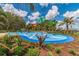 A vibrant community splash pad with playful water features, landscaping, and palm trees under a blue sky at 10962 High Noon Trl, Parrish, FL 34219