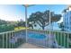 Balcony view of pool and bay with mature trees, providing a serene and picturesque setting at 1100 Imperial Dr # 507, Sarasota, FL 34236