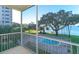 Balcony view of pool and bay with mature trees, providing a serene and picturesque setting at 1100 Imperial Dr # 507, Sarasota, FL 34236