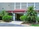 Exterior view of the entrance with lush landscaping and a welcoming pathway leading to the building at 1100 Imperial Dr # 507, Sarasota, FL 34236