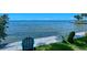 Tranquil waterfront view with Adirondack chairs on a grassy lawn, perfect for relaxation at 1100 Imperial Dr # 507, Sarasota, FL 34236