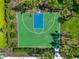 Aerial view of a basketball court featuring a green and blue surface, white lines, and landscaping at 12712 Dusty Trail Dr, Sarasota, FL 34238