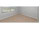 Bedroom featuring neutral carpeting, base trim, and a window with blind open to the outside at 12712 Dusty Trail Dr, Sarasota, FL 34238