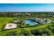 Aerial shot of the community pool with playground, beach volleyball court, and clubhouse at 12712 Dusty Trail Dr, Sarasota, FL 34238