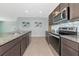 Modern kitchen with stainless appliances, granite counters, tile backsplash, and dark cabinets at 12712 Dusty Trail Dr, Sarasota, FL 34238