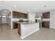 Stylish kitchen features an island, stainless steel appliances, granite countertops, and dark cabinets at 12712 Dusty Trail Dr, Sarasota, FL 34238