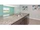 Close up on granite countertop island with stainless steel sink overlooking an open-concept living area at 12712 Dusty Trail Dr, Sarasota, FL 34238