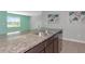 Close up on a granite countertop island with stainless steel sink overlooking an open-concept living area at 12712 Dusty Trail Dr, Sarasota, FL 34238