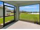 View from the enclosed lanai of a lush backyard and community pond at 12712 Dusty Trail Dr, Sarasota, FL 34238
